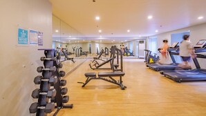 Et fitnesscenter med løbebånd, håndvægte og træningsmaskiner.