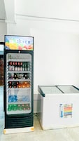 A beverage vending machine with a 'ICE' sign and a freezer unit beside it.