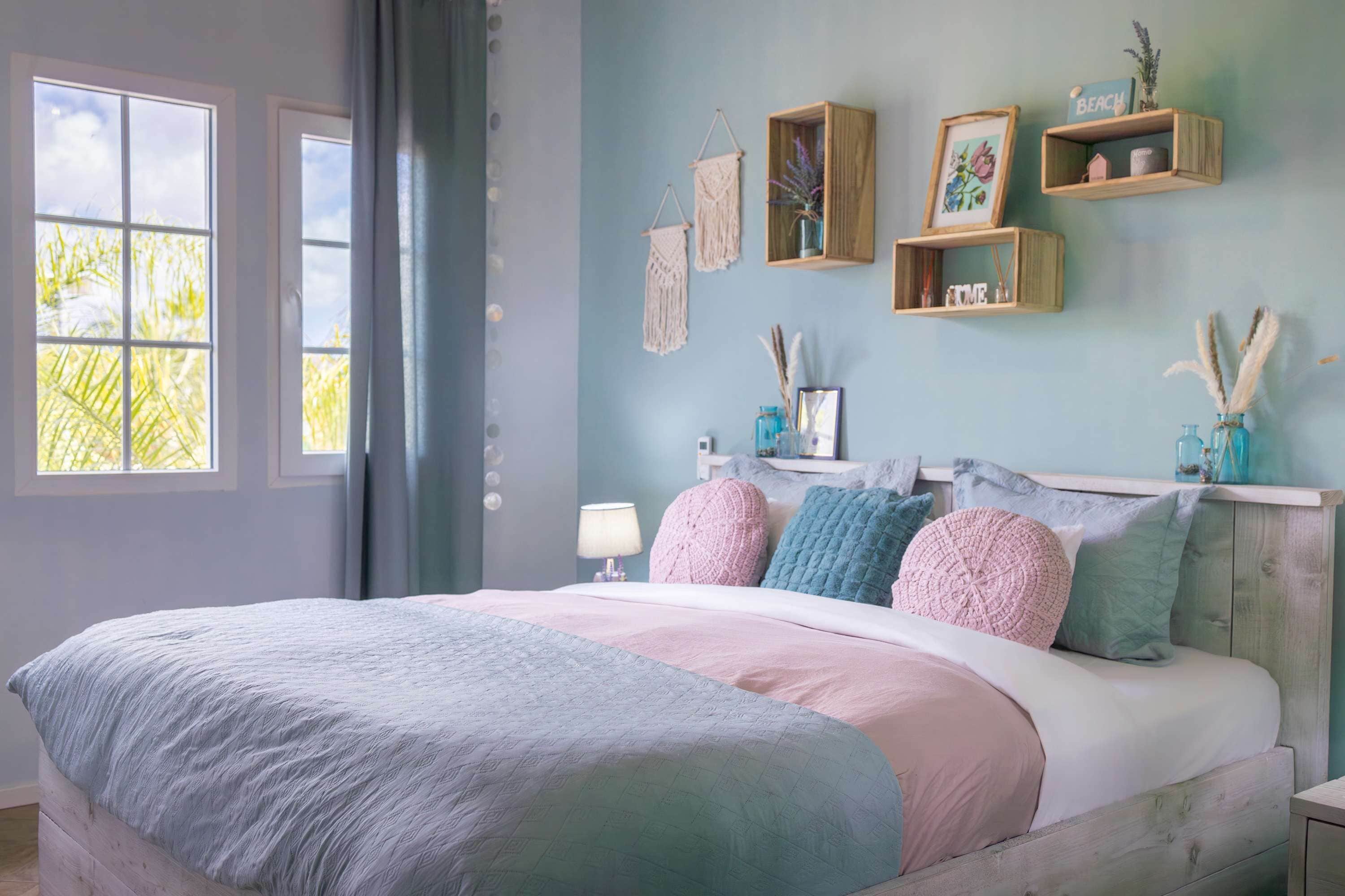 A bedroom with a bed, a window, and wall decorations.