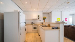 A modern kitchen with white cabinetry, a built-in oven, and a sink. - Stunning Balcony View Spacious 2BR Apt at Unique Location (Willemstad)