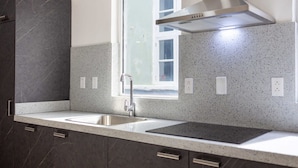 Una cocina moderna con encimeras de granito, electrodomésticos de acero inoxidable y un ventanal que deja entrar luz natural.