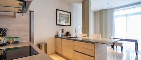 A modern kitchen with a central island, wooden cabinets, and a dining area with a table and chairs.
