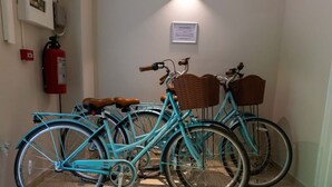 A teal bicycle with wicker baskets and brown leather seats parked indoors. - Chic Historic Townhouse in City Centre Willemstad (Willemstad)