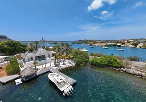 A coastal property with a dock, clear water, and boats.