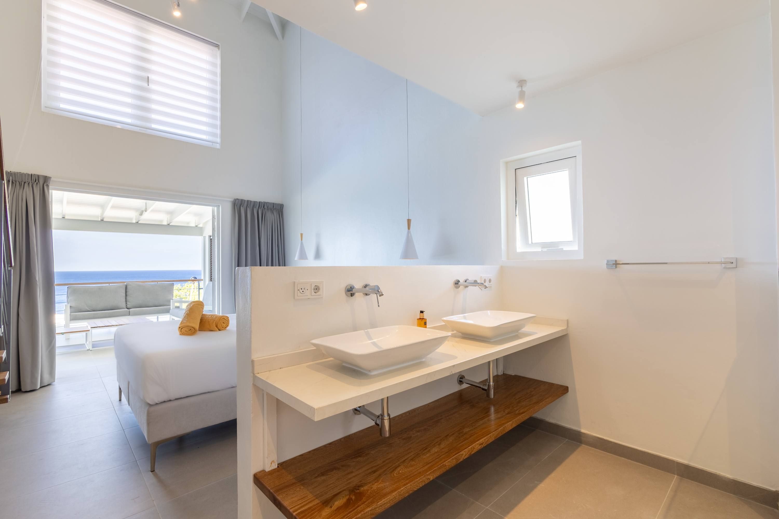 Ein modernes Badezimmer mit zwei Waschbecken, einem großen Spiegel und einer Holzausstattung.