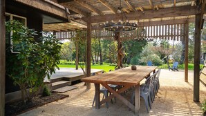 An outdoor patio with a wooden table and chairs, surrounded by a wooden pergola and a garden. - Charming Retreat near Healdsburg – 3 BD + Den, Outdoor Dining (Healdsburg)