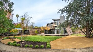 A modern two-story house with a landscaped backyard, including a patio, a small garden, and a wooden deck. - Charming Retreat near Healdsburg – 3 BD + Den, Outdoor Dining (Healdsburg)