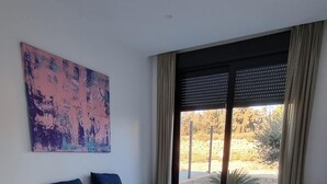 A spacious bedroom with a large bed, a view of the outdoors, and a modern design. - Moderne villa, met artistieke inrichting. dicht bij wandelpaden, zee, golfgebied (Vera)