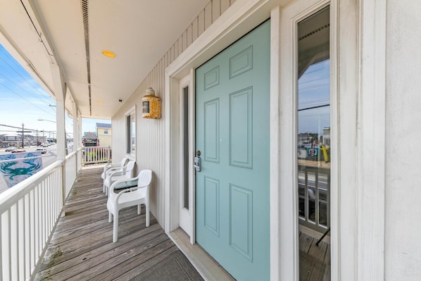 Step outside to a charming covered porch with a light blue door and comfortable seating for two.