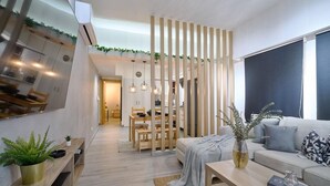 Ein modernes Wohnzimmer mit einer Couch, einem Couchtisch und einem Essbereich mit Holzkubatur.