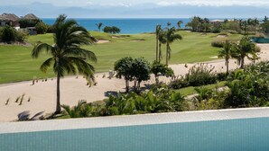 A golf course with a pool in the foreground, a beach, and a view of the ocean and mountains in the background. - Lux Ocean & Bay Views, Full Access, 2 Golf Carts, Plunge Pool, Cook/Cleaning (Punta de Mita)