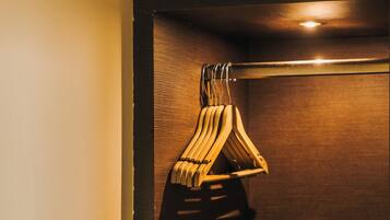 A wooden door with a metal handle and a wooden coat rack with hangers.