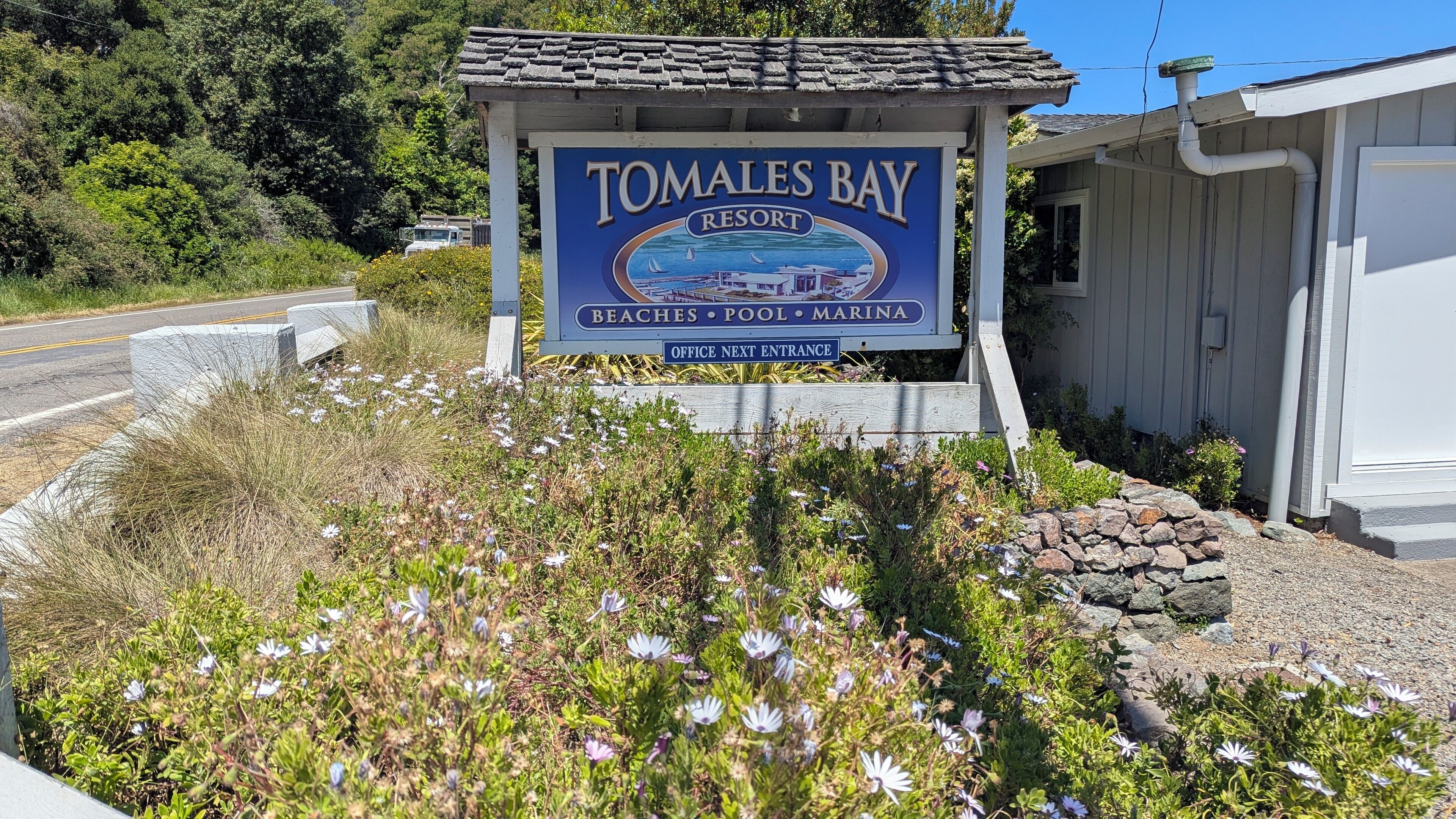 A sign for Tomales Bay Resort with amenities listed as beaches, pool, and marina.