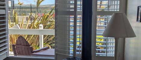Ein Zimmer mit einem großen Fenster, einem Sofa, einer Lampe und einem kleinen Heizgerät.