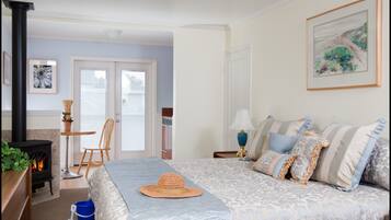 Une chambre à coucher avec un lit, une cheminée, une fenêtre et une porte.