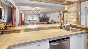 A modern kitchen with a wooden countertop, a dishwasher, and a sink. - The `VIEW` a place for quality country living (Mont-Tremblant)