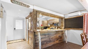 A rustic kitchen with a wooden bar area labeled "COCKTAILS," a microwave, and a chalkboard. - The `VIEW` a place for quality country living (Mont-Tremblant)