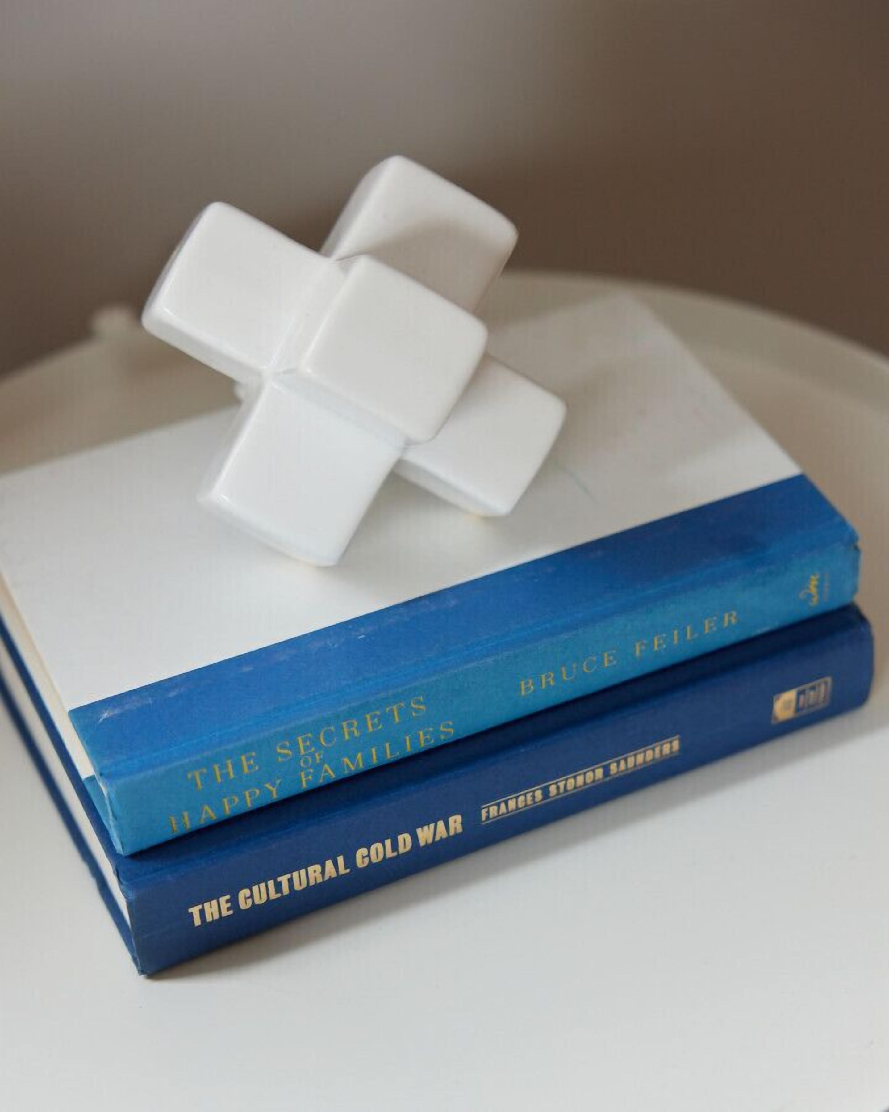 A stack of books with a white object on top.