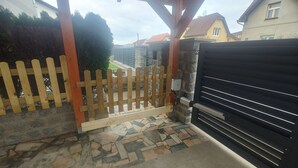A gated entrance with a stone wall and a wooden fence. - Vu's Home - Apartment Junior - 40m2 (Hlavní město Praha)