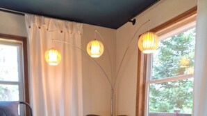 Ein Schlafzimmer mit einem Bett, einem Sessel, zwei Fenstern und einer Stehlampe.