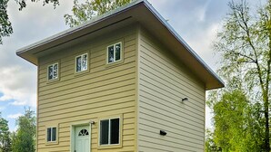 A two-story building with a flat roof, a front door, and a small porch with steps. - Quiet and Cozy getaway cabin in Hatcher Pass, Alaska; 15 min. from Palmer! (Palmer)