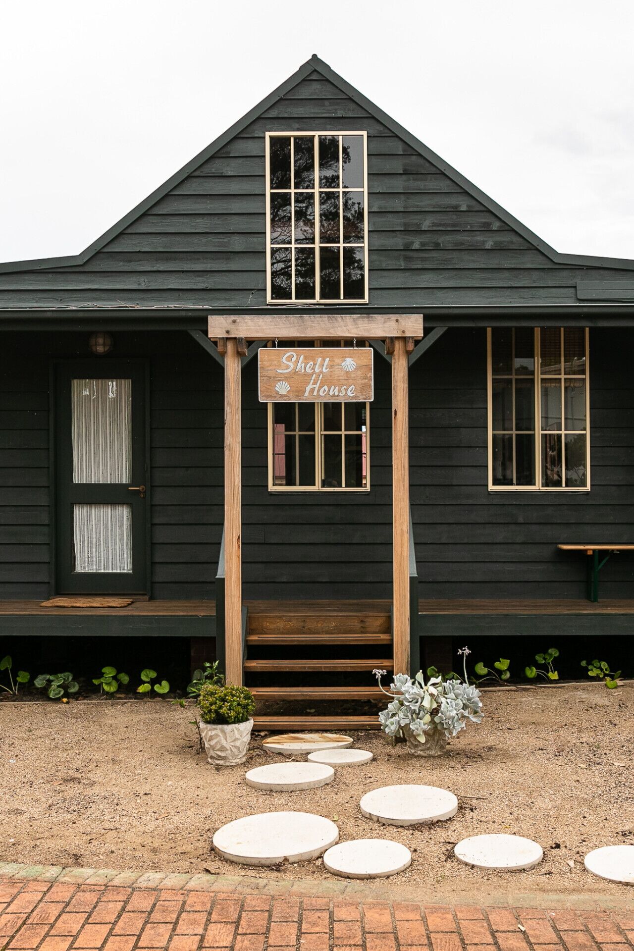 A wooden house with a sign reading "Shell House" above the entrance.