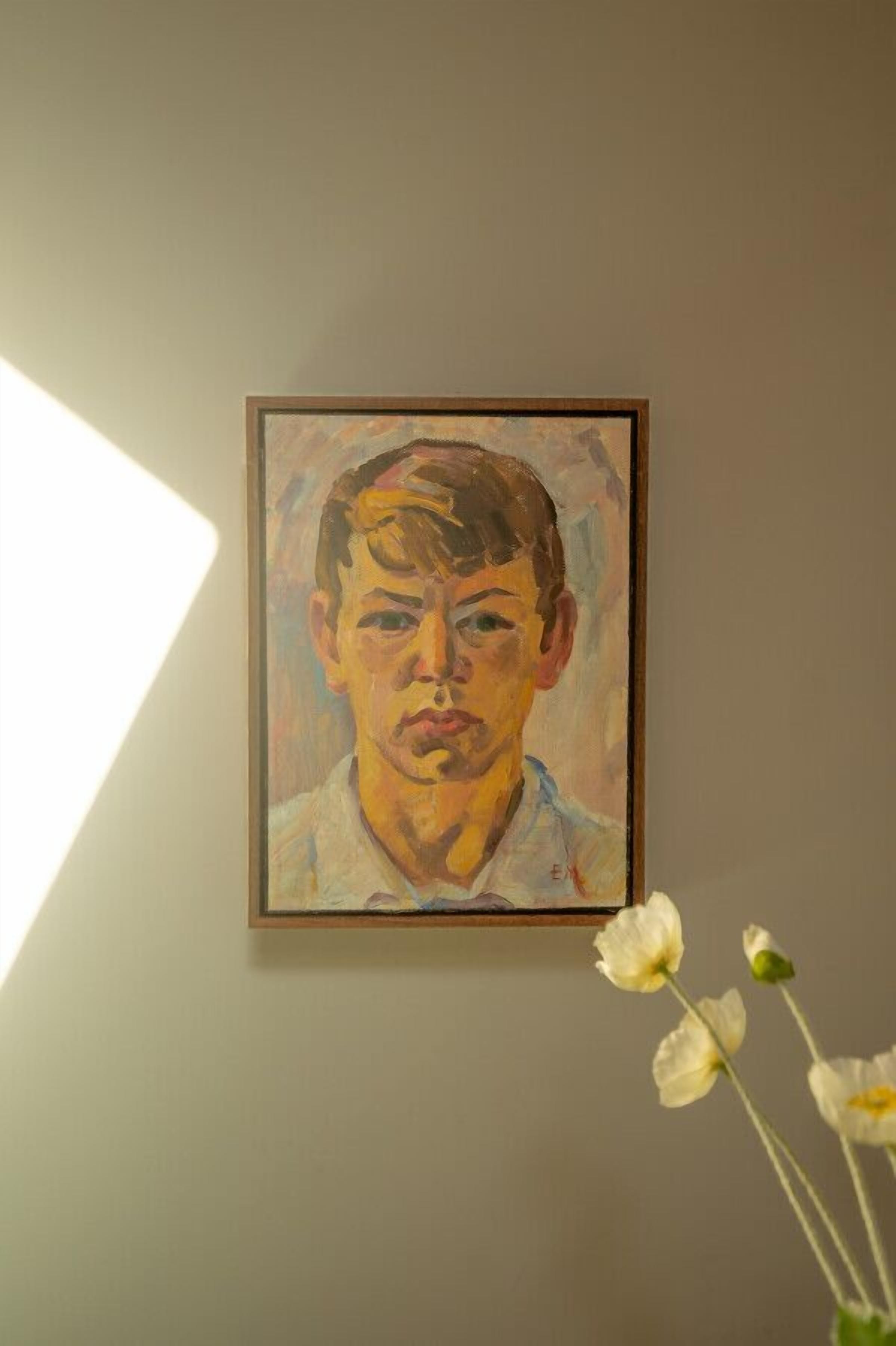 A framed portrait on a wall with a vase of white flowers to the right.