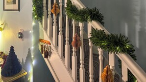Eine Treppe mit weißen Balustraden, verziert mit grünen Girlanden und goldenen Verzierungen.