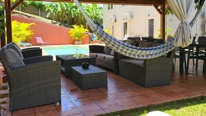 An outdoor patio with wicker furniture, a hammock, and a pool. - Grande Anse Haut de Villa 6 Pers, Piscine Privée, mer et Commerces 6mn à Pieds (Les Trois-Îlets)