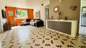 A spacious living room with a patterned tile floor, a sofa set, a coffee table, and a dining area with a white cabinet. - Grande Anse Haut de Villa 6 Pers, Piscine Privée, mer et Commerces 6mn à Pieds (Les Trois-Îlets)
