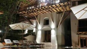 Un edificio moderno con un diseño arquitectónico único, que cuenta con una gran piscina y reflejos cristalinos.