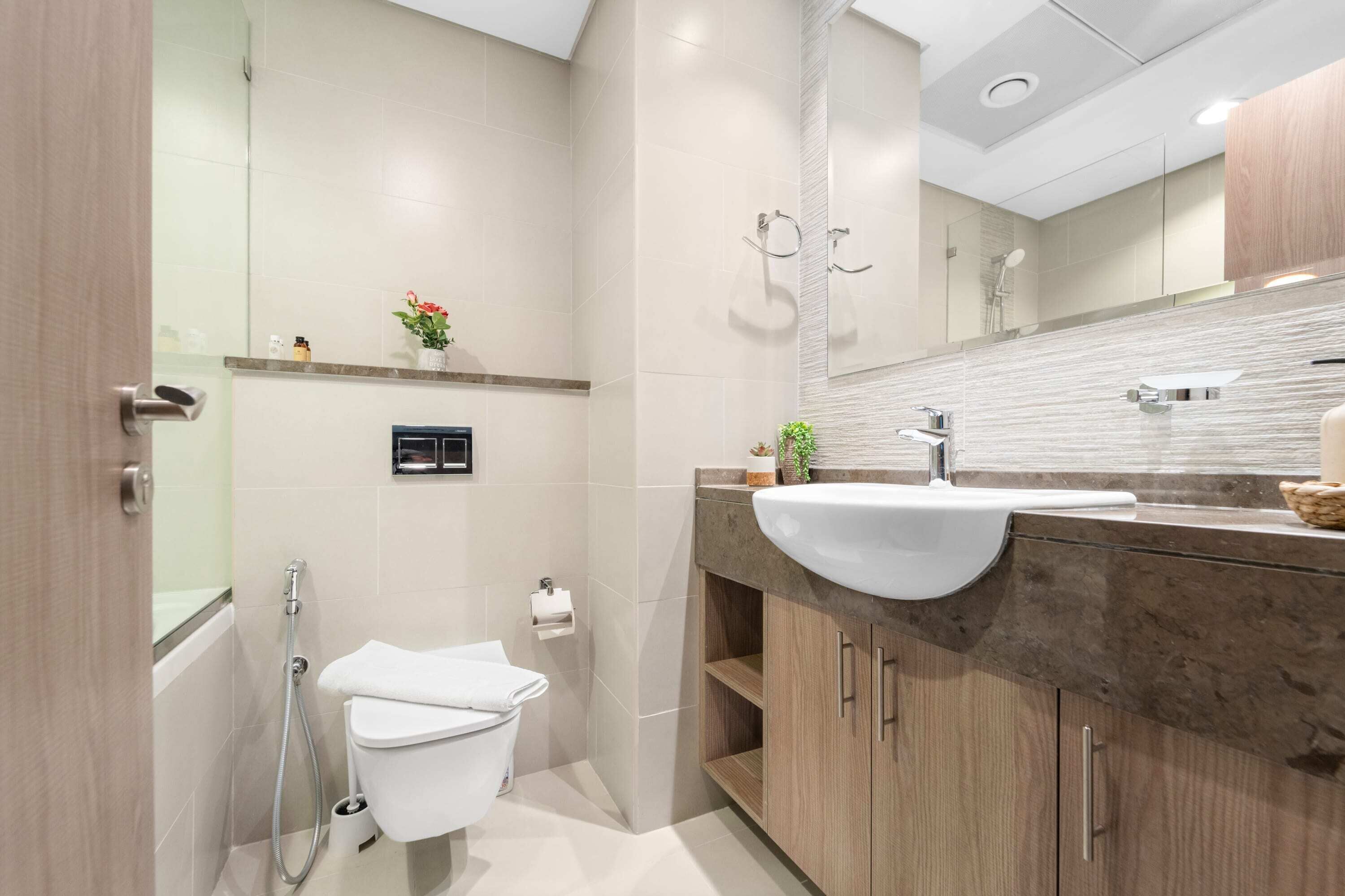 Een moderne badkamer met toilet, wastafel en douche.