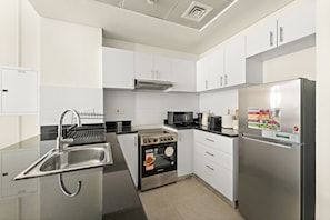 Exclusieve studio | Privékeuken | Een koelkast, een magnetron, een oven, een kookplaat