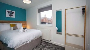 Una camera da letto con un letto, una finestra, un termosifone e un armadio.