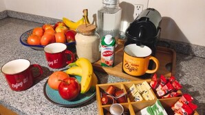 A kitchen counter with various food items, a coffee maker, and two mugs. - Terraza & Loft San Ángel (Mexico City)