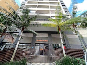 A multi-story building with a sign reading "SETIN DOWNTOWN" and balconies.