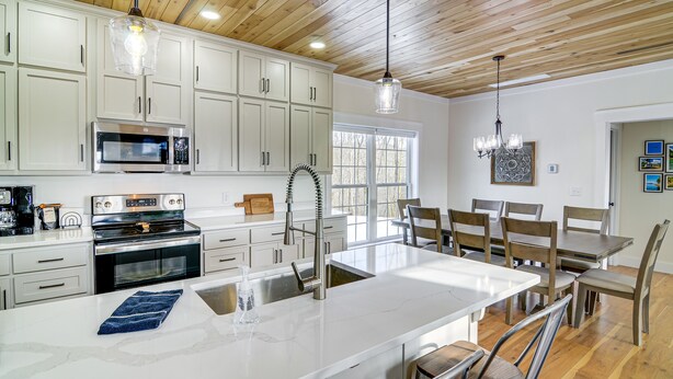 Una cocina moderna con armarios blancos, electrodomésticos de acero inoxidable y una isla grande con asientos.