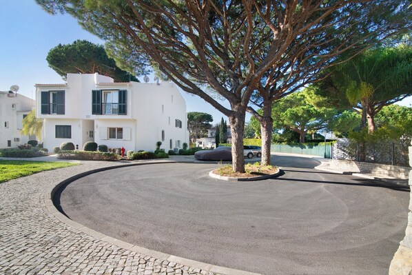 A modern two-story house with a driveway, a tree, and a parked car.