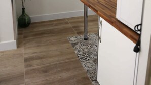 Une cuisine avec un plan de travail en bois, un réfrigérateur blanc et une horloge murale.