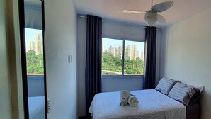 Ein Hotelzimmer mit Bett, Deckenventilator und einem Vorhangfenster.