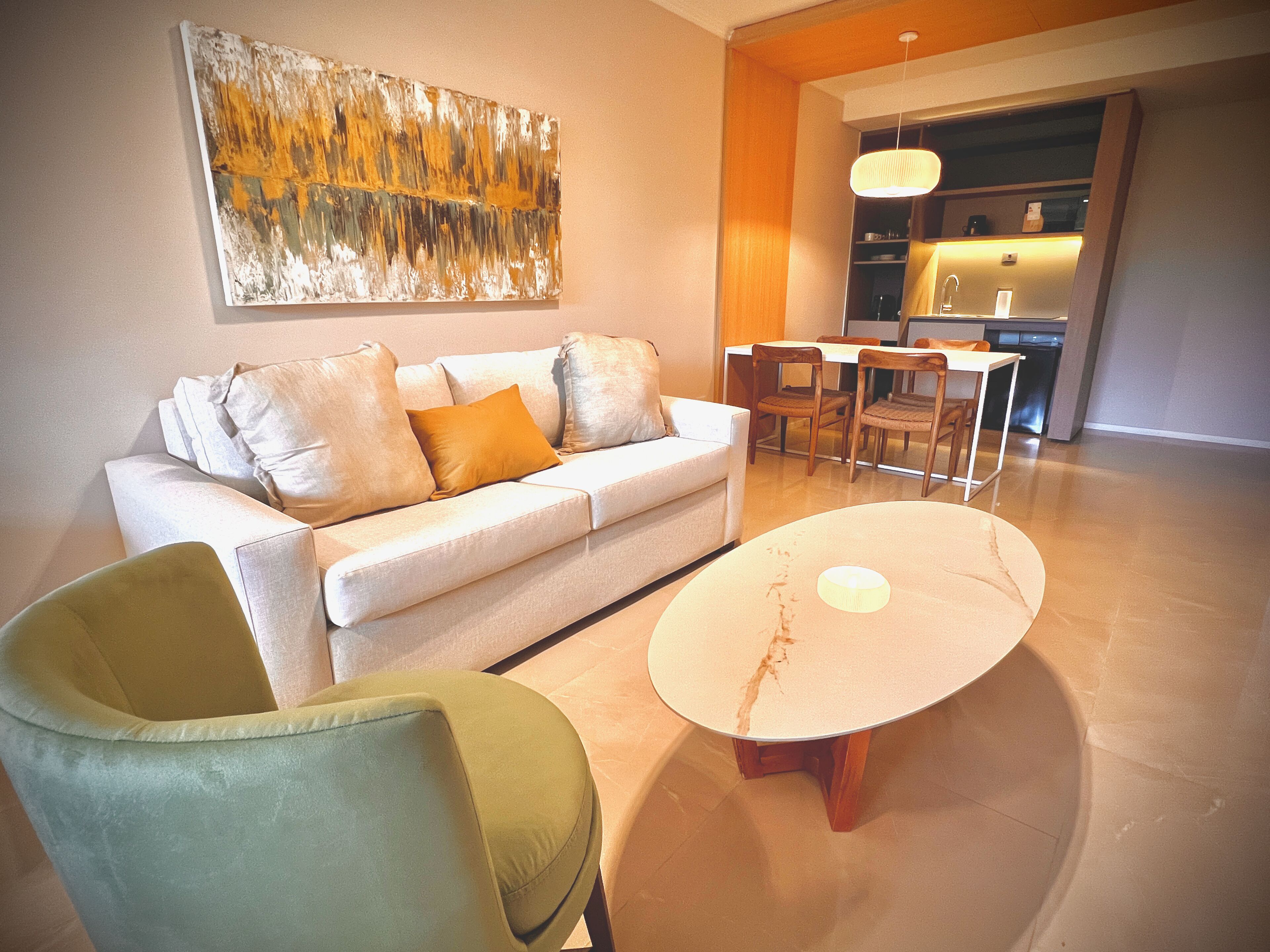 A modern living room with a sofa, a coffee table, and a dining area.