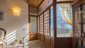 A room with a large window, a wooden cabinet, and a decorative vase.