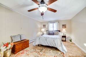 Cozy bedroom with a central bed, wooden dresser, and patterned rug.