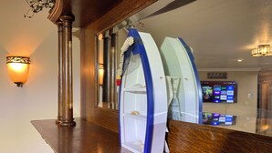 A reception desk with a wooden finish, a wall-mounted light fixture, and a digital screen displaying various options. - Hidden Bliss-Large 4 bedroom home at Mt Storm Lake (Mount Storm)