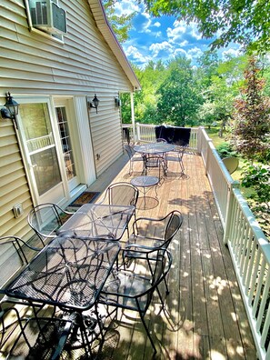 A wooden deck with outdoor furniture, a covered barbecue area, and a white fence. - Hidden Bliss-Large 4 bedroom home at Mt Storm Lake (Mount Storm)