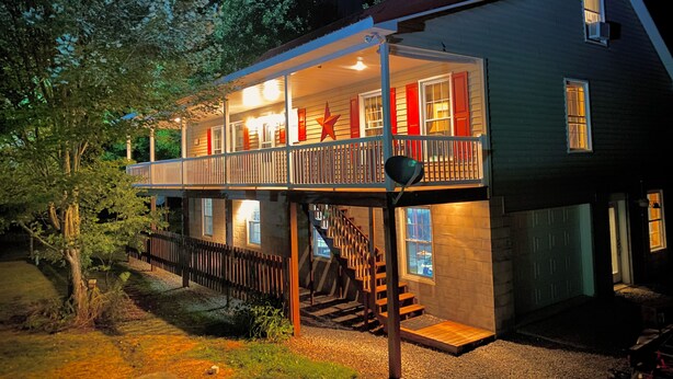 A two-story house with a balcony and a staircase leading to the upper floor. - Hidden Bliss-Large 4 bedroom home at Mt Storm Lake (Mount Storm)