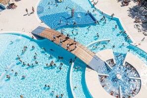 Una amplia piscina exterior con varias pistas y una zona de terraza de madera.