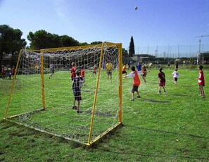 A soccer field with a goalpost and players.
