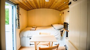 Une petite chambre comprenant un lit, une table et un four à micro-ondes.