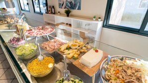 A buffet with various food items including meats, cheeses, and salads.
